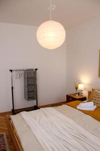 ein Schlafzimmer mit einem großen Bett und einer Leuchte in der Unterkunft Bohome apartman - FREE PARKING in Vranje