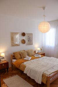 ein Schlafzimmer mit einem großen Bett und einer Hängeleuchte in der Unterkunft Bohome apartman - FREE PARKING in Vranje