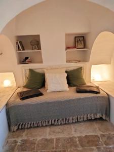 a bed in a room with an arched ceiling at Il Trullo del Nonno a Cisternino in Cisternino