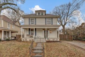 una casa bianca con portico e recinzione di Exquisite two-story home located in Midtown a Memphis