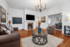 a living room with a table and a fireplace at Exquisite two-story home located in Midtown in Memphis