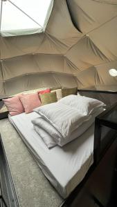 ein Bett in einem Zelt mit Kissen darauf in der Unterkunft Hvítuborgir in Minni-Borg