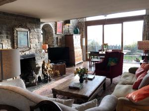 a living room with a couch and a fireplace at Peaceful stone barn conversion in Somerset in Hurcot
