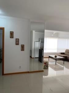 ein Wohnzimmer mit einem Sofa und einem Tisch in der Unterkunft Apartamento Capão da Canoa in Capão da Canoa