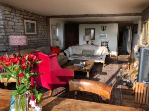 a living room with a couch and a table at Peaceful stone barn conversion in Somerset in Hurcot