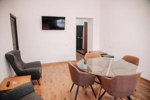 a dining room with a glass table and chairs at Argishti Hotel in Vanadzor