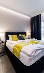 - une chambre avec 2 lits dotés d'oreillers jaunes et blancs dans l'établissement Apartamenty Gdansk EU - Dwie Motławy - OLD TOWN, à Gdańsk