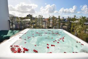 una piscina con flores rojas en el agua en Chez Soleil, Cobertura com Jacuzzi e Vista Mar P1408, en Florianópolis