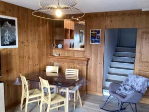 ein Esszimmer mit einem Tisch, Stühlen und einer Treppe in der Unterkunft Charmant appartement avec vue lac in Talloires