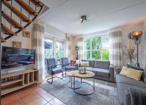 ein Wohnzimmer mit einem Sofa und einem TV in der Unterkunft Private, 5-star vacation home on a beautiful island in De Cocksdorp