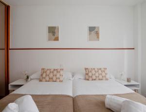 1 dormitorio con 2 camas y paredes blancas en 165A Apto moderno 2 dormitorios en Gijón