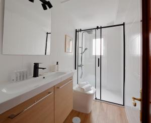 baño blanco con ducha y lavamanos en 165A Apto moderno 2 dormitorios en Gijón