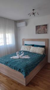 una camera da letto con 2 asciugamani cigni su un letto di Apartmani Stari Aerodrom a Podgorica