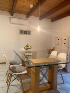 a dining room with a glass table and white chairs at Ferienhaus am Silbersee Leni in Frielendorf