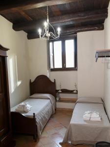 1 dormitorio con 2 camas y lámpara de araña en Casa Vacanze Nicola e Lina, en Tortorella