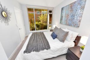 a bedroom with a white bed and a window at Duet Executive Stay in Victoria