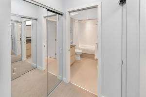 a bathroom with a toilet and a glass door at Duet Executive Stay in Victoria