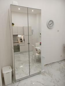 um chuveiro de vidro num quarto branco com uma cozinha em Maison Riefolo em Barletta
