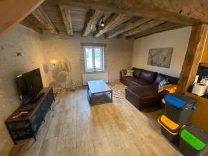 a living room with a couch and a tv at Gite des Colverts in Lailly-en-Val