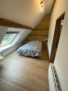 1 dormitorio en el ático con cama y ventana en Gite des Colverts, en Lailly-en-Val