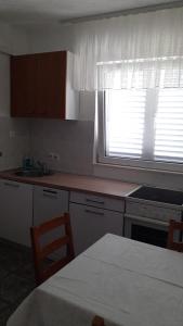 cocina con ventana y mesa con sillas en Apartments Zdenka, en Marina