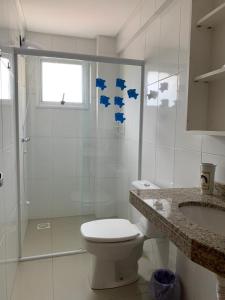 a bathroom with a toilet and a shower and a sink at Apartamento Capão da Canoa in Capão da Canoa