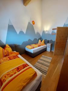 1 dormitorio con 2 camas y un mural de montañas en Fewo Baurechthof, en Goderschach