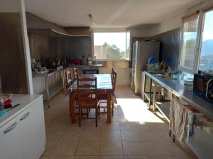 eine Küche mit einem Tisch und Stühlen in der Unterkunft Ducourneau Grimaldi in Moltifao