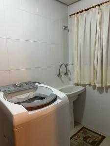 y baño con aseo y lavamanos. en Apto 3 Quartos Centro Gramado, en Gramado