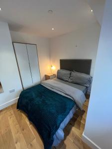 a bedroom with a large bed with a blue blanket at Lovely apartment in the centre of Croydon in Croydon
