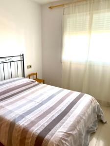 um quarto com uma cama e uma janela em El Nostre em Deltebre