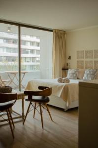 1 dormitorio con cama y ventana grande en Loica Suites, en Santiago
