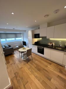 a kitchen and living room with a table and a couch at Lovely apartment in the centre of Croydon in Croydon