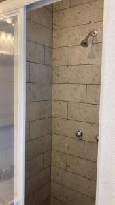 y baño con ducha y pared de piedra. en Apartment & private terrace Sunlight residence, en Ciudad de México