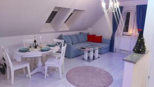 een woonkamer met een tafel en een blauwe bank bij Apartamenty Malwa in Lądek-Zdrój