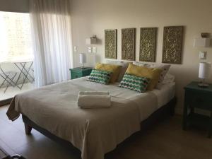 una camera da letto con un grande letto con cuscini di Loica Suites a Santiago