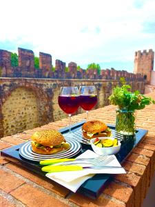 uma bandeja de comida e dois copos de vinho tinto em CA' DEL SOLE - Attico Panoramico in Centro Storico em Montagnana