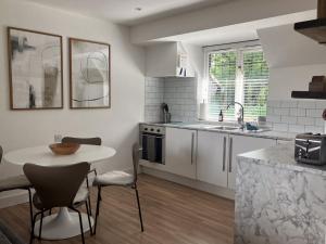 a kitchen with a table and chairs and a sink at Beautiful Annex Apartment with off street parking in Potters Bar