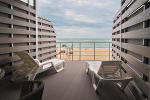 balkon z 2 krzesłami i widokiem na plażę w obiekcie Apart-Hotel Poseidon w Odessie