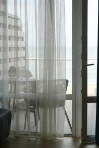 einen Tisch und einen Stuhl vor einem Fenster in der Unterkunft Apart-Hotel Poseidon in Odessa