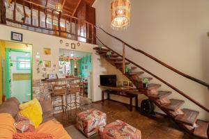 Sala de estar con escalera, sofá y mesa en CasinhaPiri, en Pirenópolis