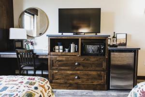 Un dormitorio con un tocador con TV. en Ninepipes Lodge en Polson