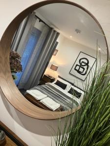 een spiegel in een kamer met een bed in een kamer bij Beautiful Annex Apartment with off street parking in Potters Bar