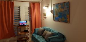 un soggiorno con un divano e una televisione di Résidence le Belvedere de Gissac a Sainte-Anne