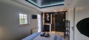 - une chambre avec un lit et un plafond bleu dans l'établissement Le Refuge du Bugey, à Saint-Sorlin-en-Bugey