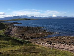 a large body of water with mountains in the background at Quinag - luxury villa with sea views in Achiltibuie in Achiltibuie