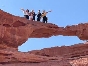 a group of people standing on top of a rock formation at Golden Sands Camp in Wadi Rum