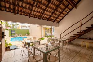 a patio with tables and chairs and a swimming pool at CasinhaPiri in Pirenópolis