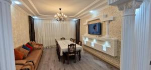 a dining room with a table and a couch at Qafqaz Resort Harmony in Gabala