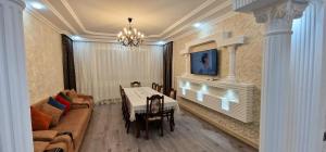 Un comedor con una mesa y un sofá. en Qafqaz Resort Harmony, en Gabala